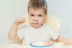 baby in the kitchen eating fruit puree photo