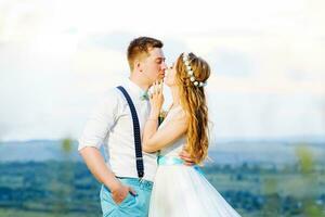 happy bride and groom kissing in nature photo