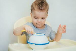 the kid in the kitchen eats milk porridge photo