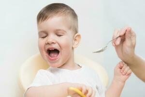 Mom feeds the baby and he turns away and does not want to eat photo