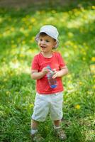 handsome boy drinks clear water from a bottle on a sunny day outside photo