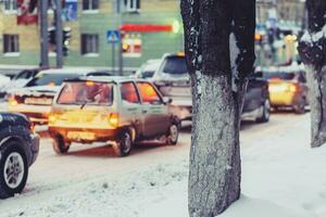 cars go on a snowy road in the evening photo