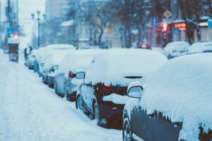 cars are parked along the roads covered in snow photo