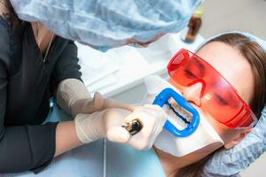 Preparing the oral cavity for whitening with an ultraviolet lamp. Close-up photo