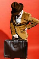 man posing in studio with suitcase in hands photo