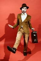 man posing in studio with suitcase in hands photo