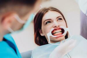 doctor orthodontist performs a procedure for cleaning teeth photo