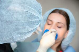 Preparing the oral cavity for whitening with an ultraviolet lamp. Close-up photo