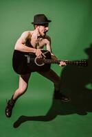 naked guy playing guitar in studio photo