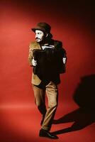 man posing in studio with suitcase in hands photo