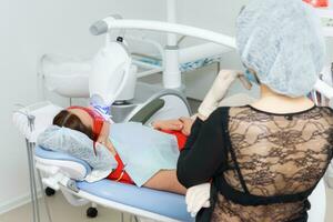 the patient undergoes a procedure for teeth whitening with an ultraviolet lamp photo