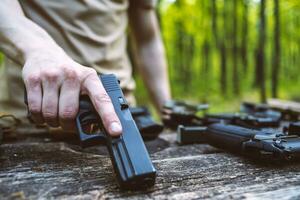 guy in the woods tests his weapons for shooting sports photo