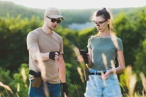 the instructor teaches the girl to shoot a pistol at the range photo