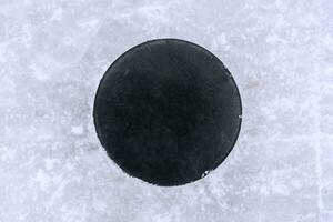 hockey puck lies on the snow close-up photo