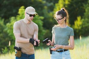 the instructor teaches the girl to shoot a pistol at the range photo