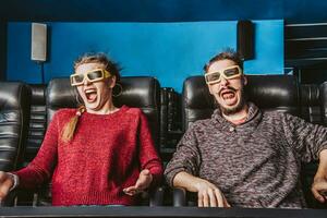 chico y niña 3d lentes son muy preocupado mientras acecho un película en un cine foto