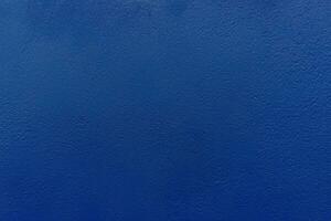 Plaster surface of the wall painted in blue. photo