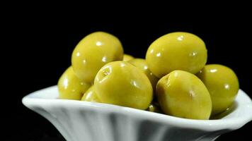 Green olives fruit gyrating on black background video