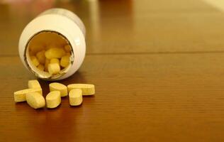 Pills on Table Surface with Open Container photo