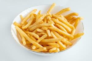 Crispy fries in a plate on white background. Hot american fast food. photo