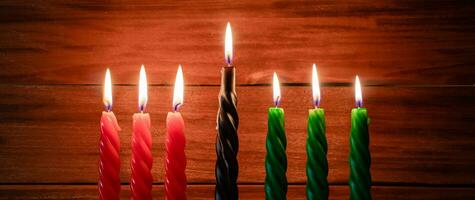 Happy Kwanzaa. African American holiday. Seven burning candles, red, black and green, in kinara candlestick. photo