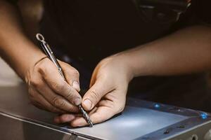 artesano mecánico trabajos con metal en taller. masculino trabajador marcas fuera edificio estructura. estilo de vida, desarrollo de pequeño negocio. foto