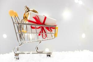 New Year shopping. Mini cart with gift boxes on white background. photo