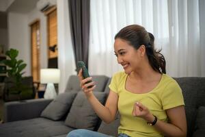 Happy young Asian woman using a smartphone and Excited to celebrate good news victory success photo