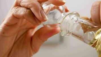 Down view of a bottle with oil opening and the oil drips in a salad bowl. Unusual angle video