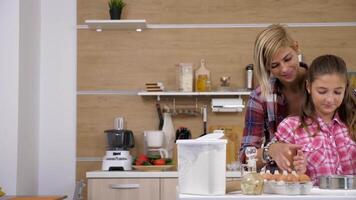 madre y hija Cocinando juntos en el cocina. ellos son cernido harina a través un tamiz video