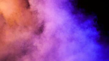 Clouds of beautiful abstract colorful smoke over a black background in studio video