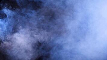 Beautiful abstract smoke clounds dispersing over a black background in studio video