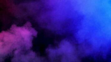 Colorful abstract blurred smoke rising over a black background in studio video