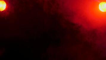 Abstract dynamic smoke over red lights on a black background video