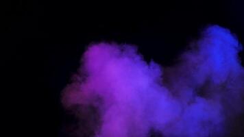 Beautiful colorful abstract smoke clouds rising over a black background in studio video