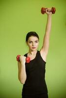 beautiful girl doing exercise with red dumbbells photo