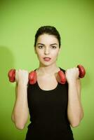 beautiful girl doing exercise with red dumbbells photo