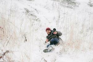 cheerful traveler photographer slipped and fell on snow photo