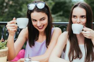 Girlfriends are sitting in coffee and drinking tea photo