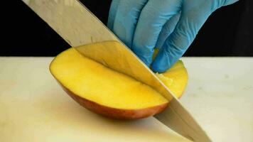 profissional chefe de cozinha mãos corte uma manga fruta para dentro fatias video