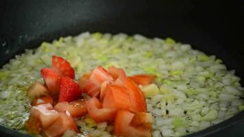 chef cuisine dans une chaud la poêle avec mangue, tomate, fraise et oignon video