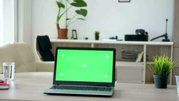 Laptop mit Grün Bildschirm auf ein Schreibtisch im das Leben Zimmer. Dolly Schieberegler Parallaxe bewirken 4k Aufnahmen video