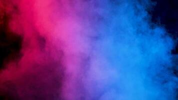 Abstract dispersing and moving clouds of colored smoke over a black background video