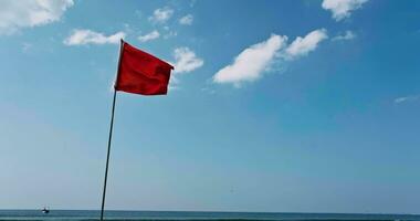 rood vlag Aan strand Aan zee of oceaan net zo symbool van Gevaar. de zee staat is beschouwd gevaarlijk en zwemmen is verboden. video