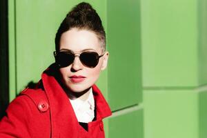 Girl in glasses posing on green background photo