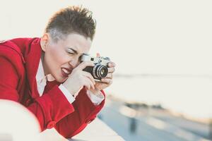 Girl taking pictures on the waterfront at sunset photo