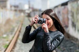 atractivo niña toma imágenes con un antiguo cámara foto