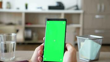 rivelatrice tiro di uomo mani Tenere un' smartpone con verde schermo croma finto su. dolly cursore 4k metraggio video