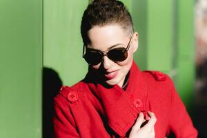 Girl in glasses posing on green background photo