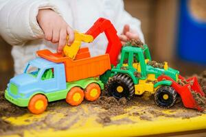 the child plays cars on the playground photo